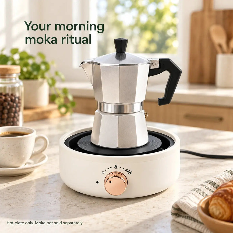 Plaque chauffante électrique blanc ivoire chauffant une cafetière italienne argentée dans une cuisine lumineuse ; cafetière italienne vendue séparément