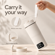 Electric cup carried by its woven wrist strap with the removable handle beside it