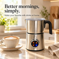Silver countertop milk frother beside a cappuccino in a bright kitchen