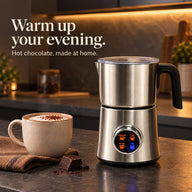 Silver milk frother beside hot chocolate in a warm evening kitchen