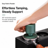 Green spring-loaded espresso tamper pressing level on a portafilter for even tamping