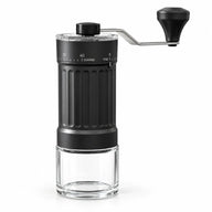 Czarny ręczny młynek Yozcoffee z ceramicznymi żarnami i odłączanym szklanym pojemnikiem na zmieloną kawę na białym tle