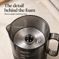 Close-up of the stainless steel frothing coil, black center spindle and metal floor inside the pitcher