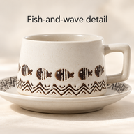 Taza y platillo de cerámica estampada: primer plano del motivo de peces y olas