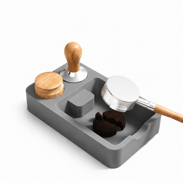Gray Yozcoffee silicone espresso tamping station mat with a portafilter, tamper, distributor, and coffee puck pieces