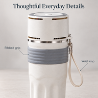 Close-up of the grey ribbed grip, electronic lid vents and beige wrist loop on the ivory travel mug