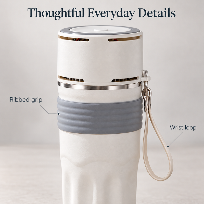 Close-up of the grey ribbed grip, electronic lid vents and beige wrist loop on the ivory travel mug