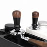 Yozcoffee walnut wood constant force espresso tamper resting on a portafilter in a coffee setup
