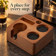 Yozcoffee wooden tamping station base beside an espresso machine on a dark coffee counter
